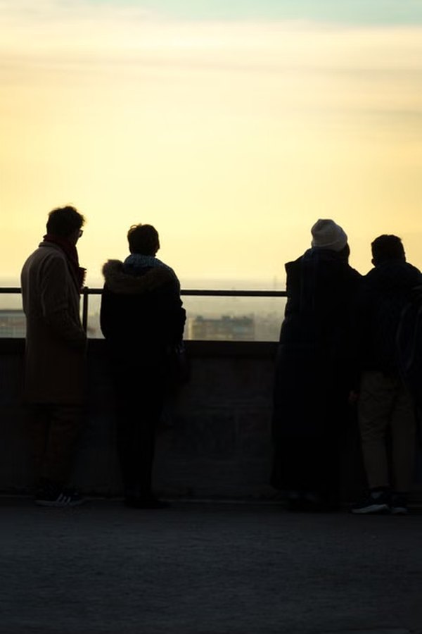 Four people looking out over the landscape together at sunrise